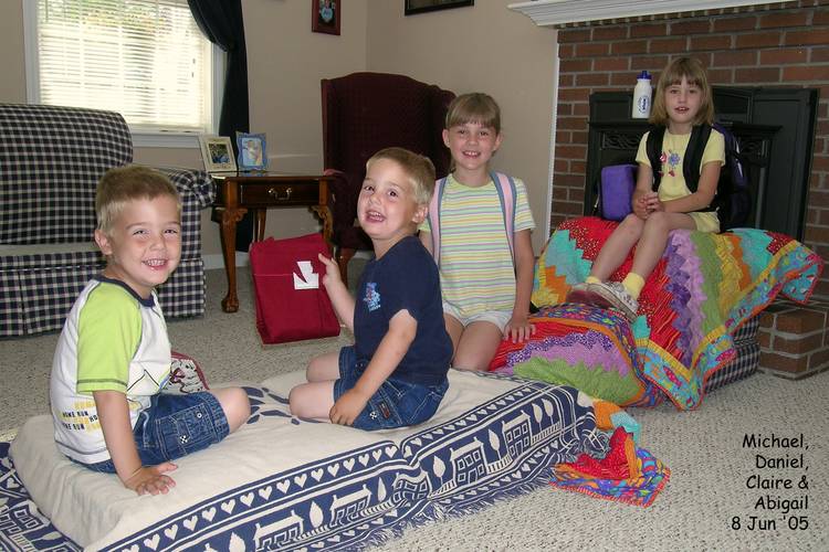 The kids make 'a bridge' out of couch cushions and blankets