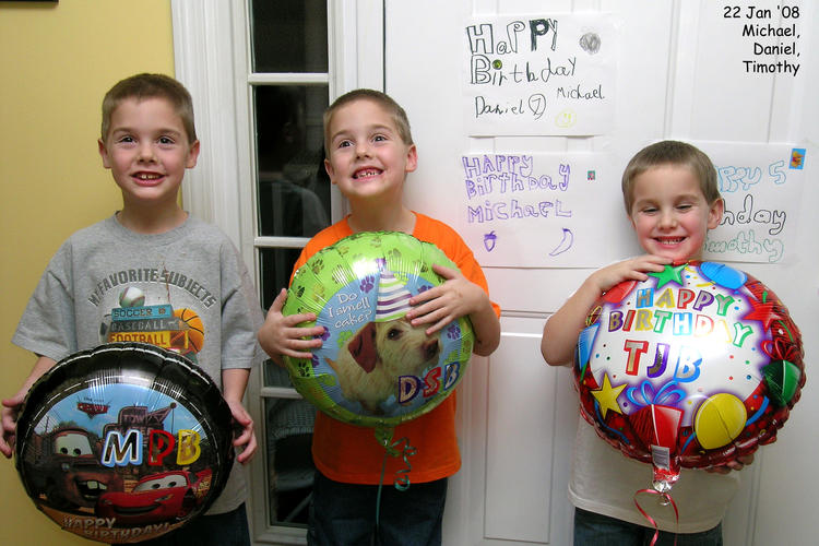 The boys holding their birthday balloons
