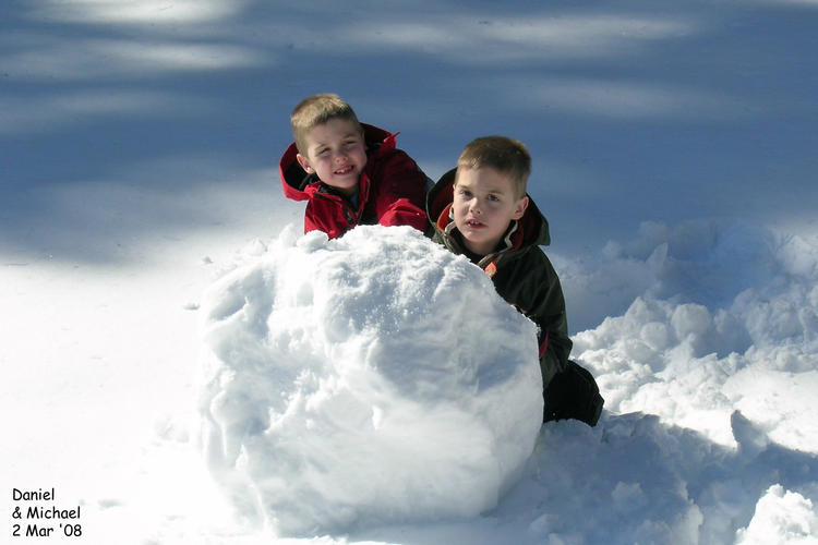 Twins working on a snowman