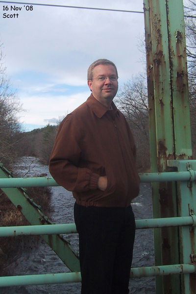Scott standing on a bridge over the Souhegan River